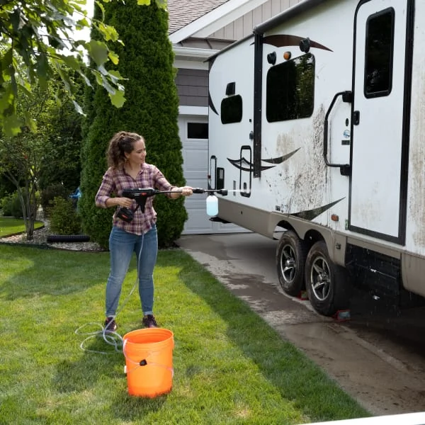RV maintenance with a power washer cleaning dirt off camper