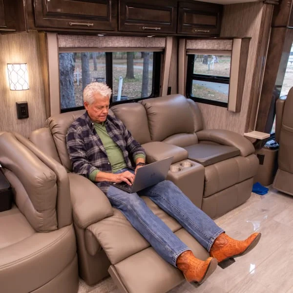 While relaxing on furniture, RV owner browses new RV furniture such as RV loveseat recliners