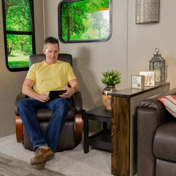 Man sits in RV recliner chair browsing Thomas Payne RV recliners next to empty RV chairs
