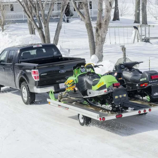 Truck hauling snowmobile cargo trailer with single axle