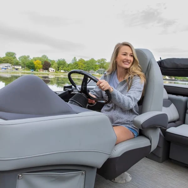 Woman Boater in Captain's Chair on a Boat Seat Pedestal Steering the Boat Woman Boater in Captain's Chair on a Boat Seat Pedestal Steering the Boat