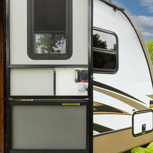 RV door open on brown travel trailer