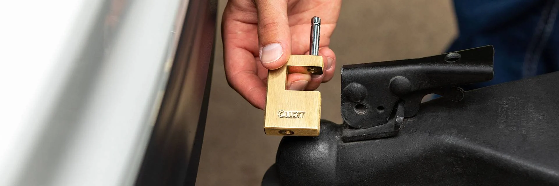 Hand Holding Boat Trailer Lock Next to Boat Trailer Coupler Hand Holding Boat Trailer Lock Next to Boat Trailer Coupler