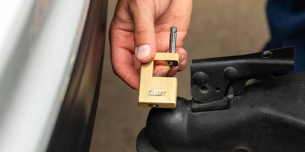 Hand Holding Boat Trailer Lock Next to Boat Trailer Coupler Hand Holding Boat Trailer Lock Next to Boat Trailer Coupler