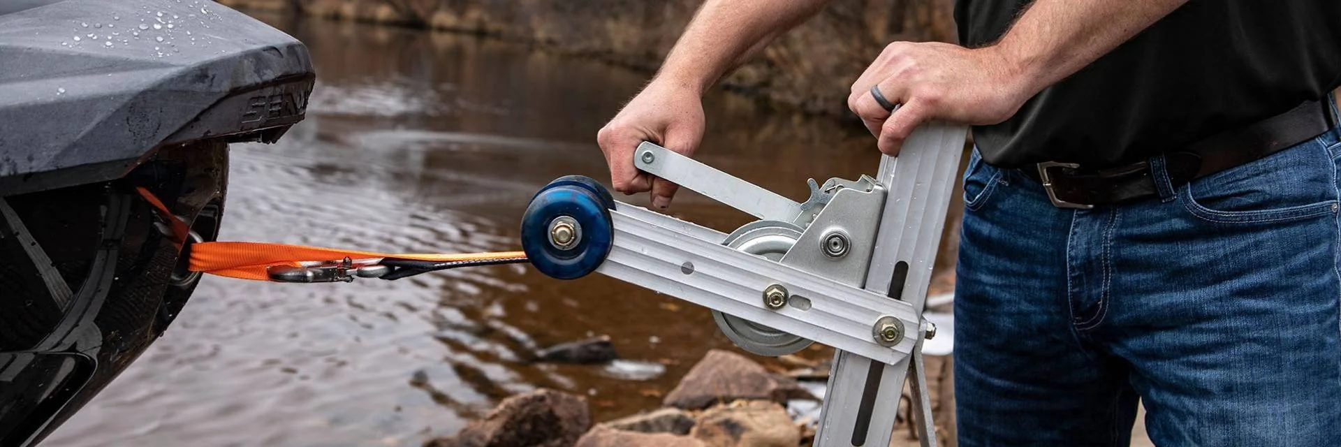 Man Pulling a Boat onto Boat Trailer Using a Boat Trailer Winch Man Pulling a Boat onto Boat Trailer Using a Boat Trailer Winch