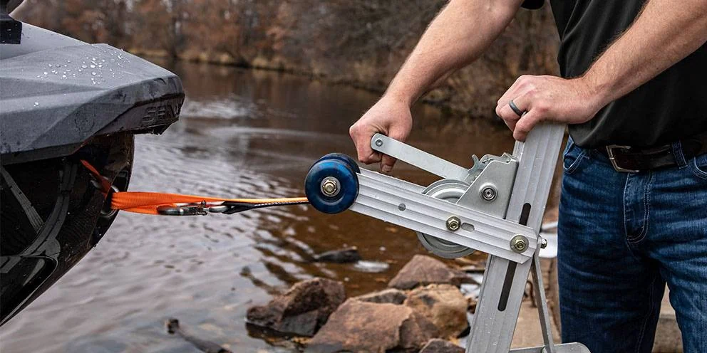 Man Pulling a Boat onto Boat Trailer Using a Boat Trailer Winch Man Pulling a Boat onto Boat Trailer Using a Boat Trailer Winch