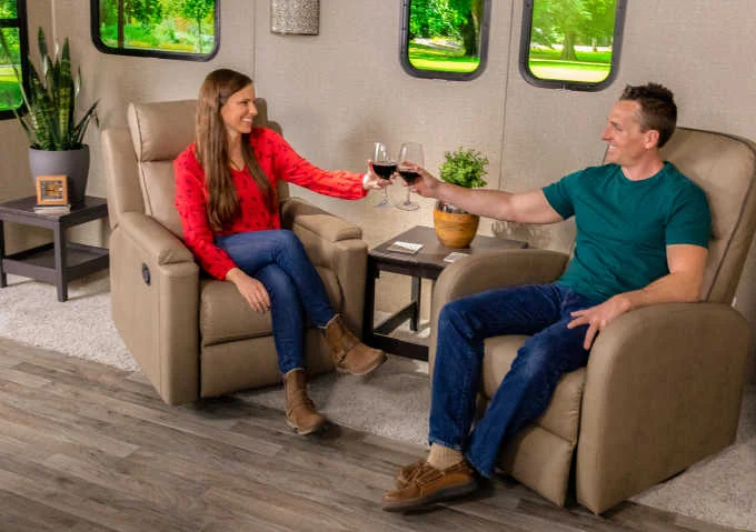 Happy couple drinking wine in RV pushback recliners