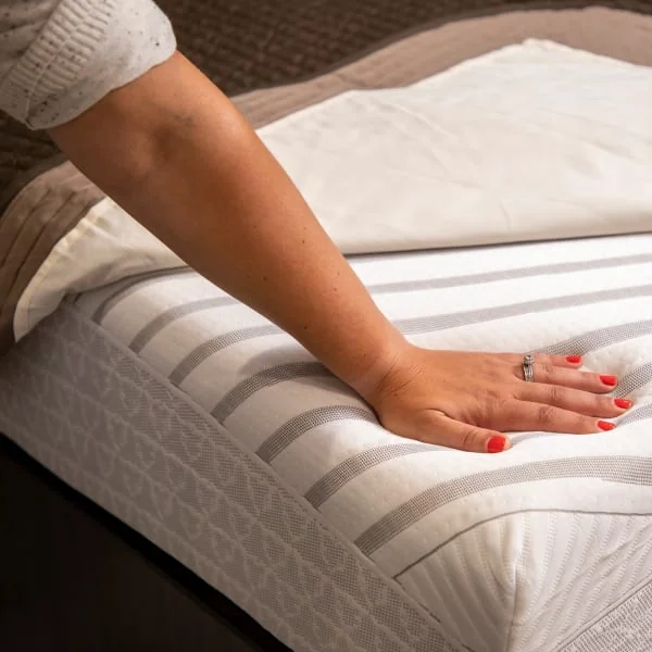 Hand presses down on RV mattress