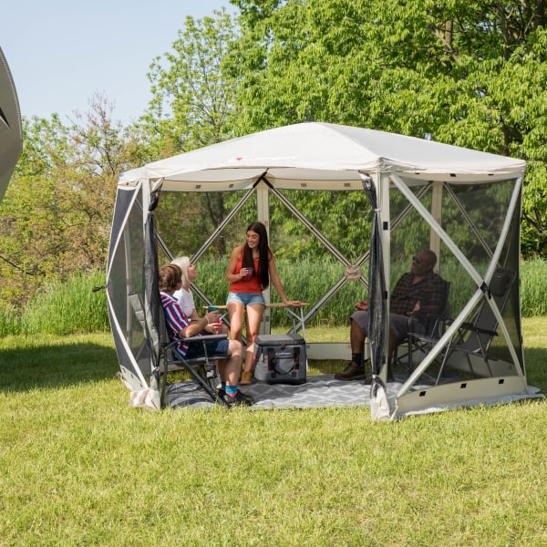 Picnic gathering in popup gazebo on grass