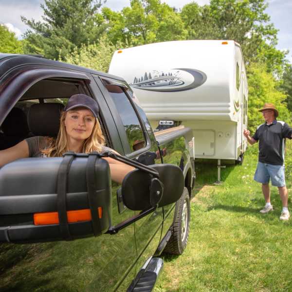 Couple hitching a 5th wheel camper to their pickup truck