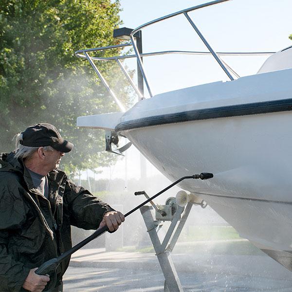 Boat owner power washing his boat before winter