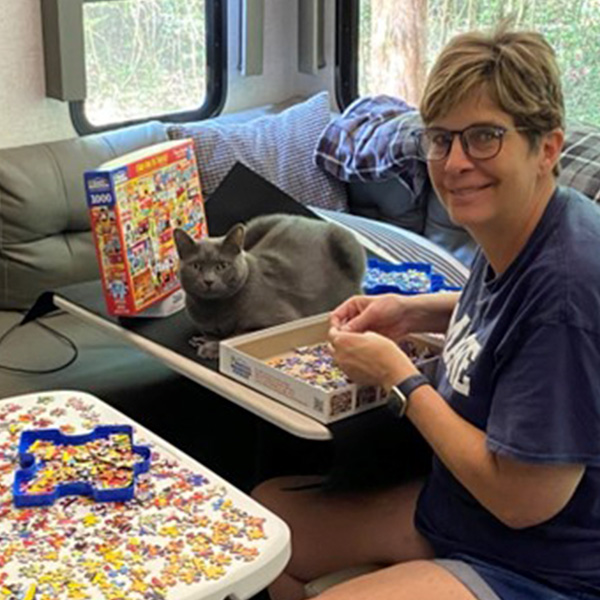 D’Anne Terrill putting together a puzzle with her cat Boomer