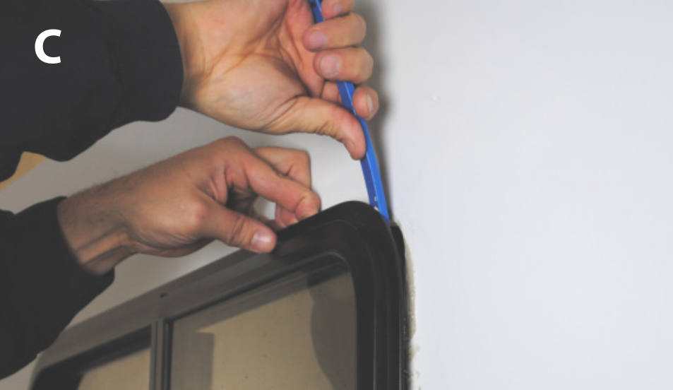 Slide a thin putty knife under the exterior window flange