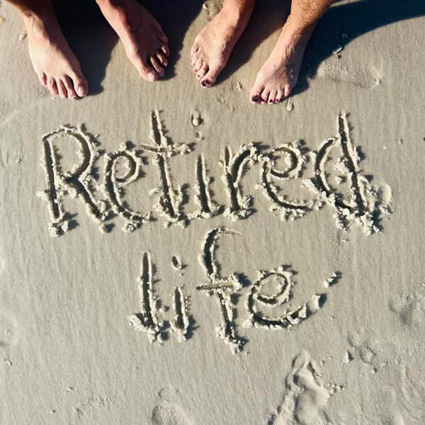 Retired life written in sand on a beach