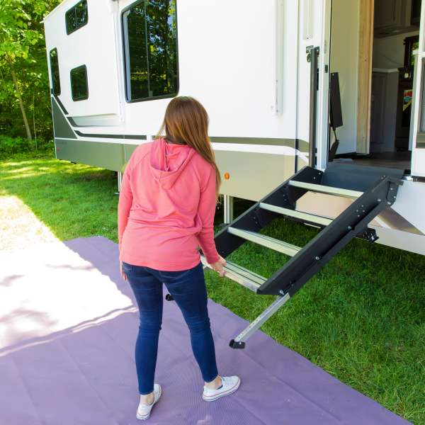Woman lifting a lightweight aluminum step into her RV entryway