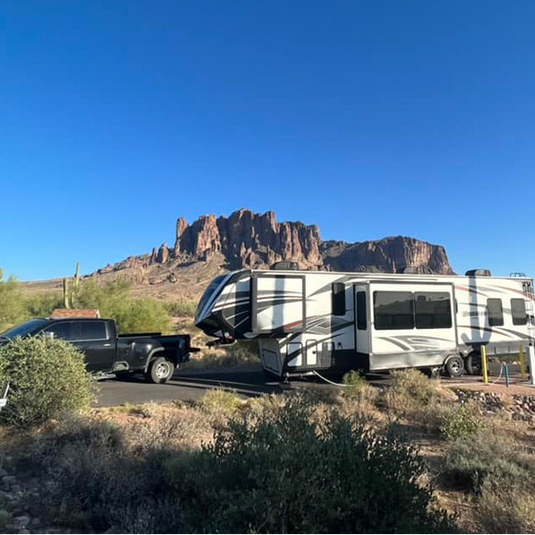 Truck pulling a fifth wheel camper in the desert
