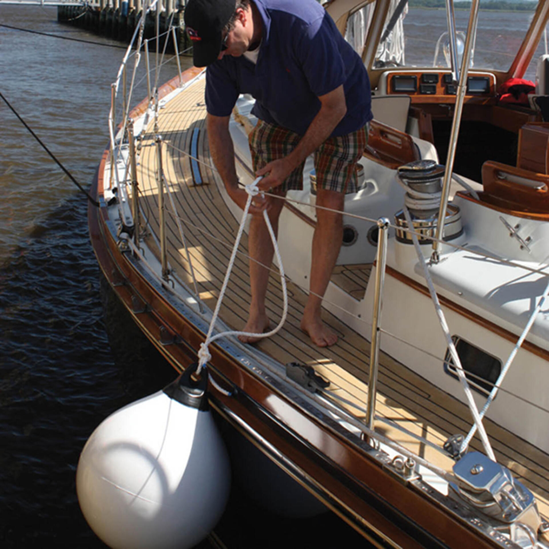 White round ball boat bumper fender tied to boat rail - fender vs. bumper