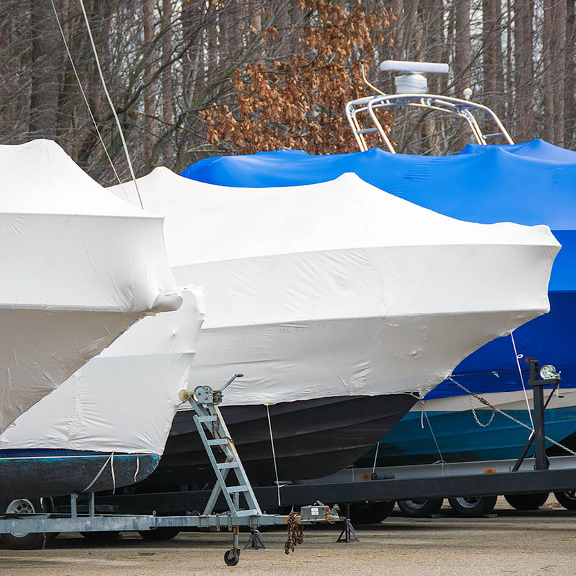 Boats parked on trailers with protective covers